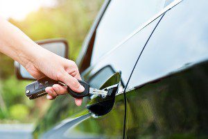 driver using key to open car