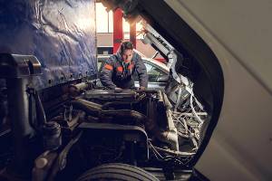truck driver making engine repairs