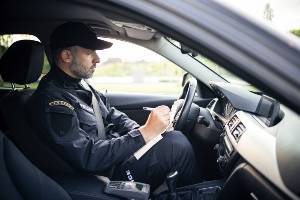 police officer taking notes in car