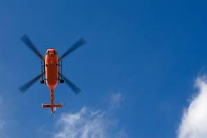 orange helicopter climbing in sky