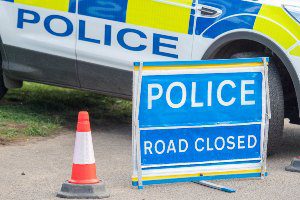 road closed sign with police suv