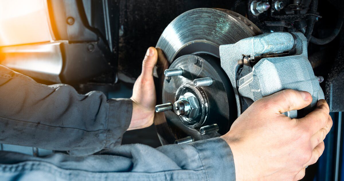 mechanic working on vehicle brakes