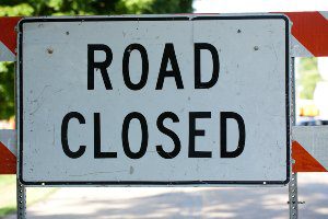 white road closed sign during daytime