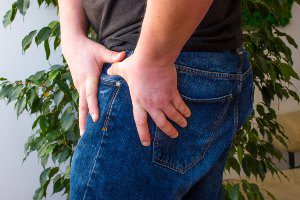 man grabbing injured hip