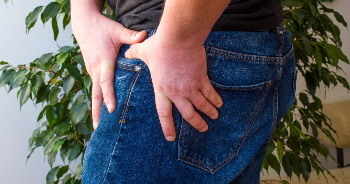 man grabbing injured hip