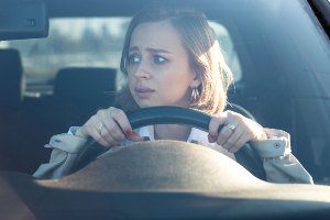 woman looking worried behind the wheel