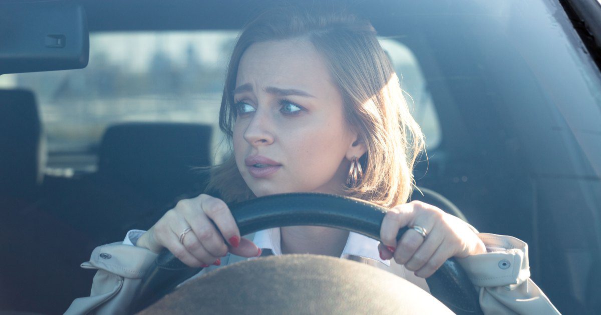 woman looking worried behind the wheel