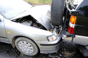 silver car crushed in back of suv