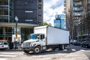 white commercial truck on corner