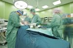 surgeons attend to patient in operating room