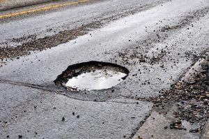 a road with a large pot hole