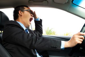 a motorist yawning behind the wheel