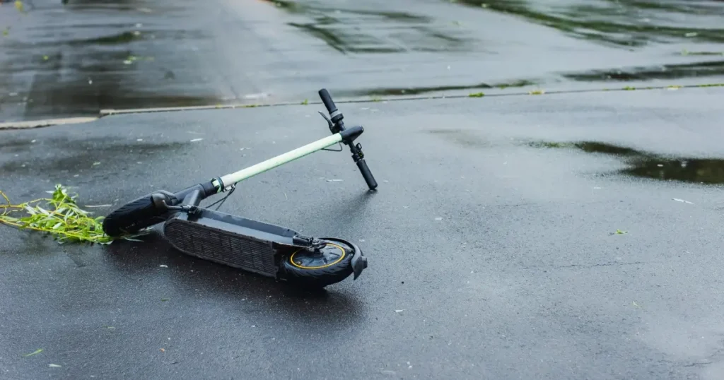 fallen scooter lying on wet road